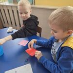 Chłopiec podnosi karteczkę z kroplami wody na wazelinie.