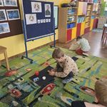 Jeden z chłopców odkłada przedmiot na właściwy dywanik_ a drugi wybiera z worka odpowiedni przedmiot.