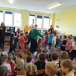 Pani w tańcu prowadzi korowód dzieci.