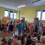 Grupa przedszkolaków tańczy przed resztą kolegów.