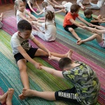BOF 12 Dzieci siedzą w parach w rozkroku trzymajac się za ręce i wykonuja skłon.jpg