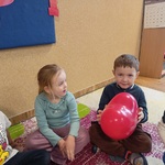 06 Przedszkolaki siedząc trzyma balon w kształcie serca.jpg