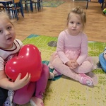 08 Dziewczynka trzyma balon siedząc przy koleżance.jpg